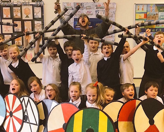 School children wielding Viking shields as part of experience day