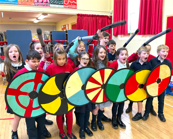 Wall of school children holding shields